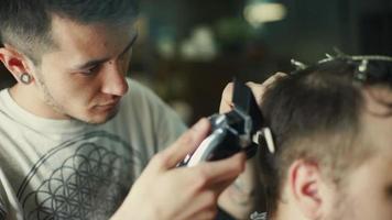 barbeiro cortando e modelando cabelos com aparador elétrico video