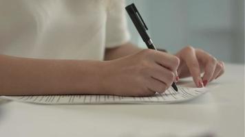 affärskvinna skriver på ett dokument på sitt kontor