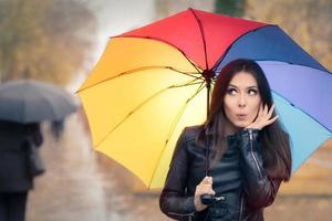 Surprised Autumn Woman Holding Rainbow Umbrella photo