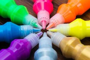 Colorful paint - bottles with colorful pigments on wooden background