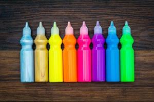 Colorful paint - bottles with colorful pigments on wooden background