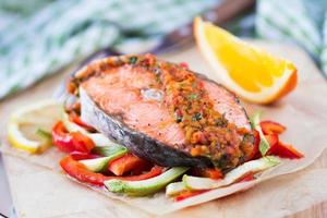 filete de pescado rojo salmón sobre verduras, calabacín y pimentón foto