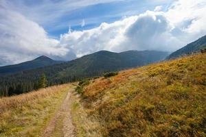 Dirt road to mountains in Carpathian photo