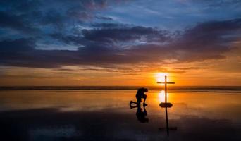 reflexionar hombre rezando cruz foto
