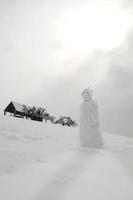 Snowman in the snowy slope photo