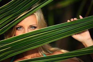 woman behind the palm leaves