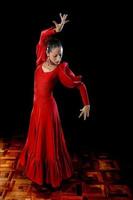 young Spanish woman dancing flamenco in traditional folk red dress photo