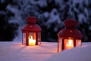 Two burning lanterns in the snow photo