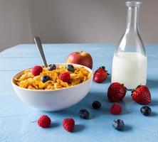 Cornflakes in a bowl with milk and fruits photo