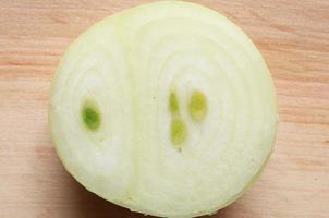 Half peeled and cut onion on wooden board photo