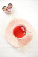 rose tea in pink cup on white table photo