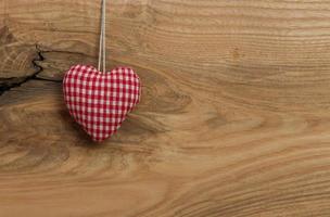 Love heart hanging on wooden texture background photo