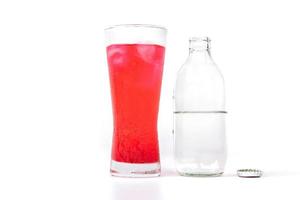 Glass of red nectar mixed with soda and soda bottle photo