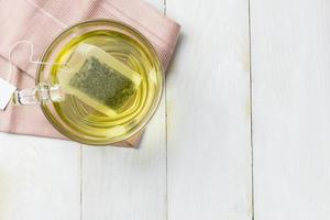 Hot green tea in glass mug photo