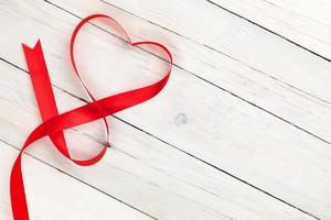 cinta en forma de corazón del día de san valentín sobre mesa de madera blanca foto
