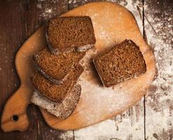 Sliced rye bread on cutting board closeup on table photo
