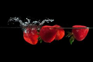 Strawberries splashing into water photo