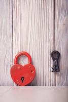 Heart shaped lock and key over light vintage wooden background