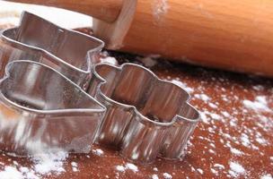 Cookie cutters and rolling pin on dough for cookies photo