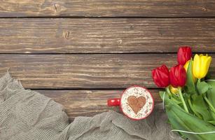 cappuccino with heart shape and bouquet of tulips photo