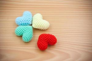 Colorful Yarn hearts on wood background