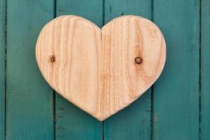 Love Valentines wooden heart on turquoise painted background