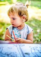 Beautiful Two year old girl drawing in a coloring book