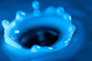 Splash of water crown on blue surface photo