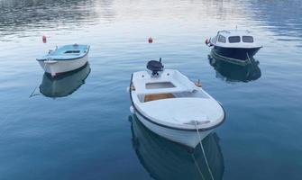 Three small fishing boat in calm water photo