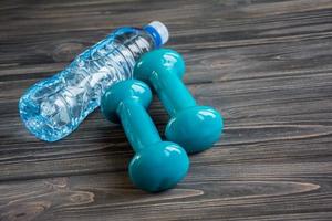 Two blue dumbbells and bottle of water photo