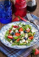 Arugula, strawberry, blueberry and blue cheese salad photo