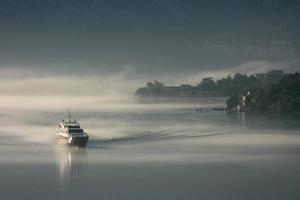 Boat emerges from early morning mist, Bay of Kotor, Montenegro