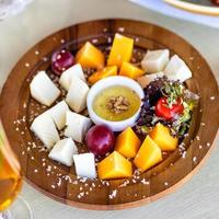 Assorted cheese with sauce on a wooden plate photo