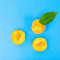 Yellow plum fruit on blue background photo
