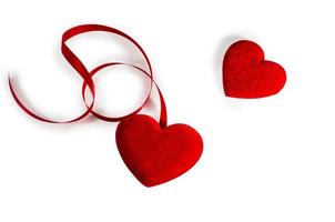 dos corazones con cinta roja aislado en blanco foto