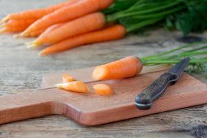 zanahoria en tabla de cortar con cuchillo foto
