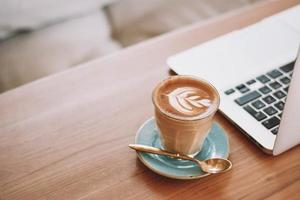 Capuchino en taza de cerámica sobre platillo foto