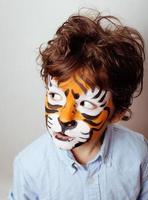 little cute boy with faceart on birthday party close up photo
