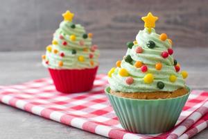 Cupcakes with Christmas tree shape on wood