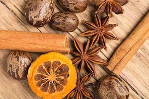 Christmas decoration on wooden background with cinnamon, orange, nuts photo