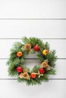 Christmas wreath on white wooden table top view