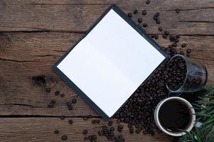 tazas de café, granos de café y un libro de registro foto