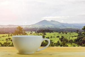 taza de café con un fondo de montaña foto