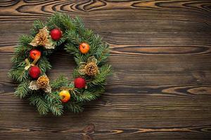 Christmas wreath on brown wooden table top view photo