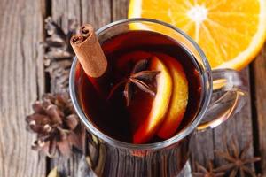 Mulled wine and spices on weathered wooden table photo