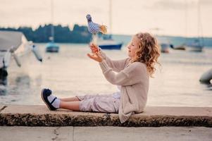 child girl playing with toy bird on seaside