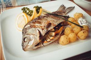 Grilled carp fish with rosemary potatoes and lemon photo