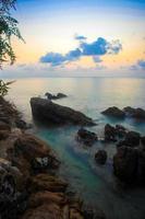 rocas, mar, puesta de sol en la playa tropical en koh phangan foto