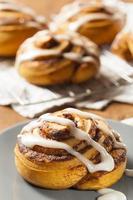 Homemade cinnamon buns with icing drizzled on top photo
