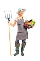 Farmer holding a pitchfork and vegetables photo